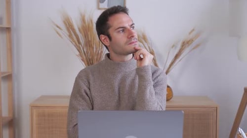 Young Adult Working at Laptop in Home Setting