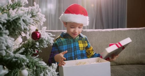 Boy Opening Christmas Present with Joyful Surprise