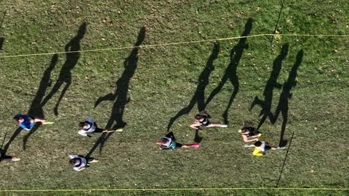 Running race grass course silhouetted athletes