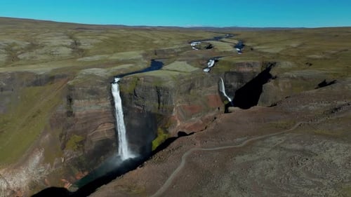 Stunning Aerial View of Icelandic Waterfall and River Cutting Green Canyon