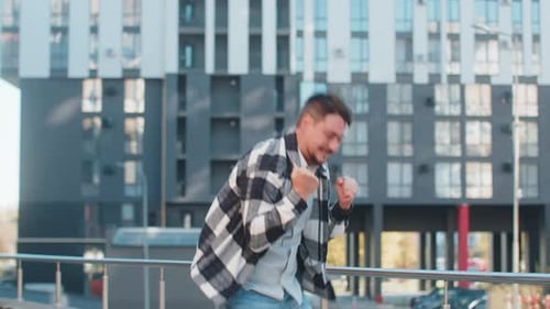 Excited Man Looking Surprised Clenching Fists Shocked By Sudden Victory Standing on City Street