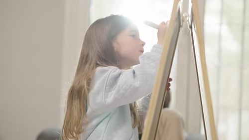 Girl Drawing on Whiteboard in Bright Sunlight