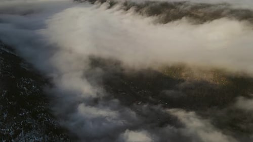 Beautiful valley covered by clouds and a town visible trough the clouds. Drone footage, Southern Nor