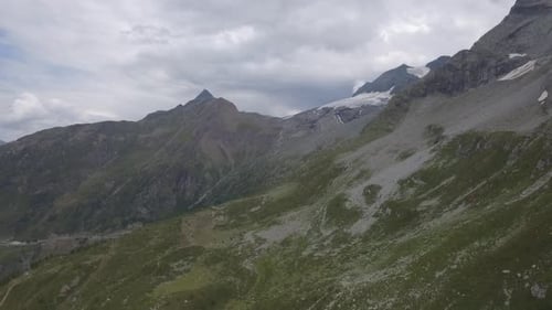 Drone flight over a high alpine mountain road pass. The drone fly`s over the barren mountain terrain