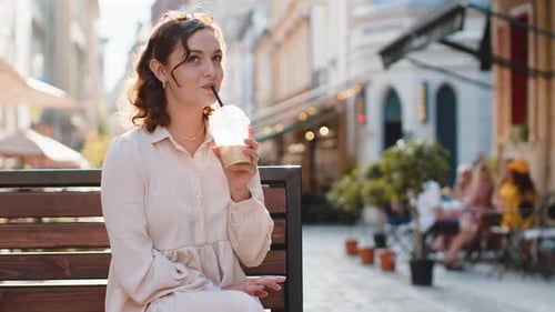 Woman Enjoying Drinking Morning Cold Coffee Drink with Ice Relaxing Taking a Break in City Street