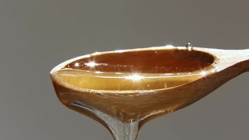 Honey Pours From a Wooden Spoon Natural Golden Sweet Food Honey