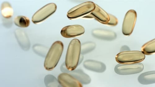 Vitamins Falling in Slow Motion on Reflective Surface