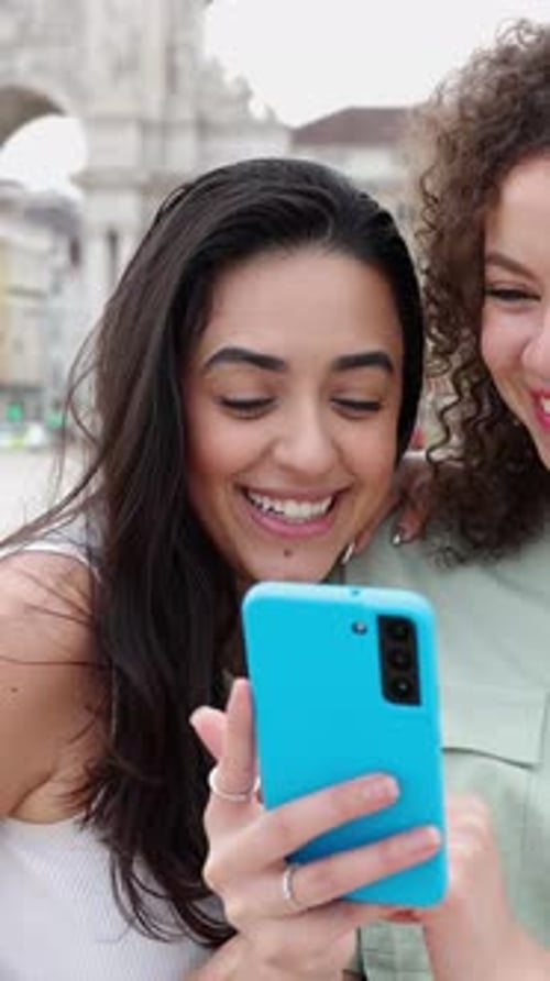 Laughing Women Looking at Phone in City