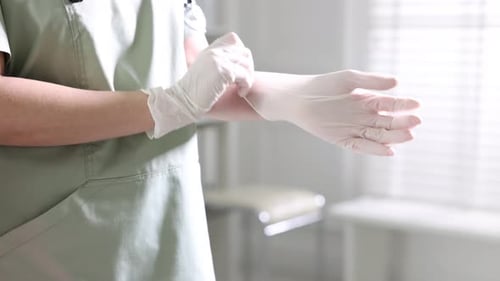 Travailleur médical mettant des gants à l'hôpital, gros plan