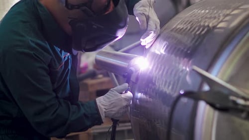 Welder, using VIG, TIG, MIG MAG method to welding stainless steel parts, close up. The welder uses a
