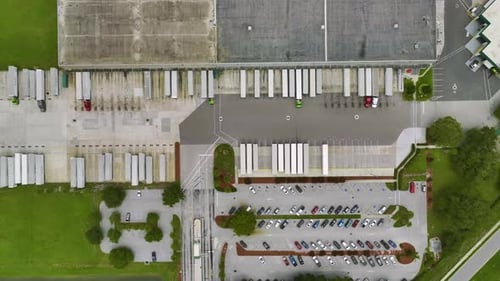 Blick aus der Vogelperspektive auf das große Kommerziell Versandzentrum mit vielen Güterwagen, die entladen und hochgeladen werden