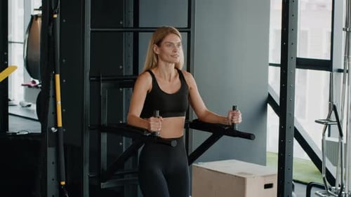 Active Middle Aged Woman Exercising on Bar at Gym Lifting Her Legs Training Abs Muscles Free Space