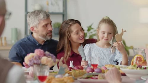 Eltern und kleine Tochter unterhalten sich beim Osteressen