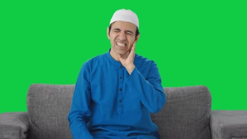 Sick Muslim man suffering tooth pain Green screen
