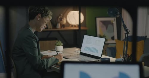 Woman Analyzing Data at Desk Late at Night
