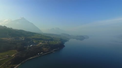 Aerial View of the Snow Rocky Cliffs with Forest By the Lake