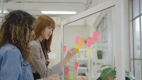 Team Working Together with Sticky Notes on Glass