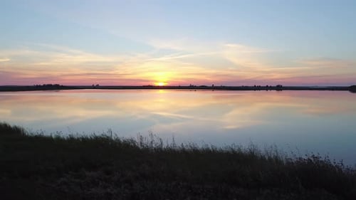 Aerial Over the Lake at Sunset Soft Sunset Skies Reflections on Calm Water Surface Stunning Summer