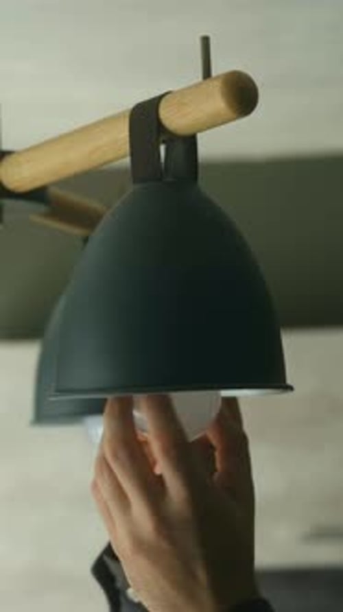Hand Screwing Led Light Bulb Into Modern Lamp Fixture