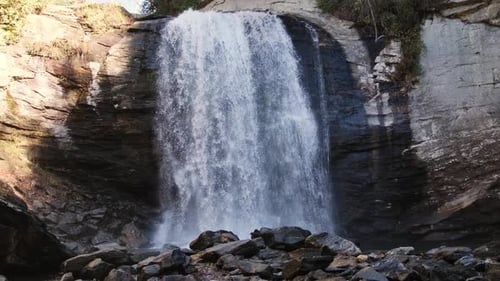 Powerful Waterfall Flowing Over Rocky Cliff