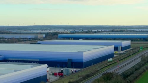 Large Logistics Warehouses Expanding Across Industrial Zone Near Highway Distribution Hub