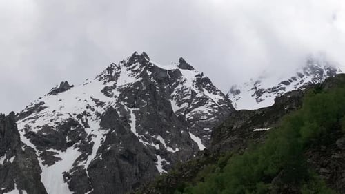 Clouds Passing Over Snow Capped Mountain Peaks