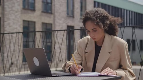 Woman Working on Laptop and Notebook Outdoors