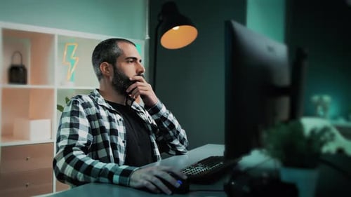 Hübscher männlicher Freelancer, Redakteur, Datenanalyst oder Designer mit Bart, der an seinem Schreibtisch arbeitet, an einem Modus