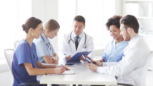 Hospital, Profession, People And Medicine Concept - Group Of Happy Doctors With Clipboard Meeting...