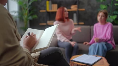 Specialist Writes Notes Listening to Mom and Daughter