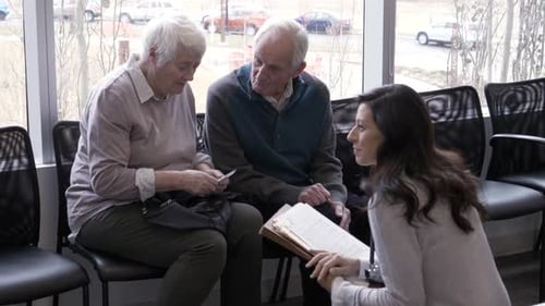 Senior Couple Consults with Doctor in Hospital Waiting Room