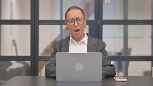 Worried Woman Using Laptop in the Office
