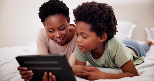 Mother and Child Using Tablet Together on Bed