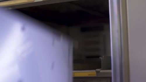 Technician installing hardware components into a server rack, close-up