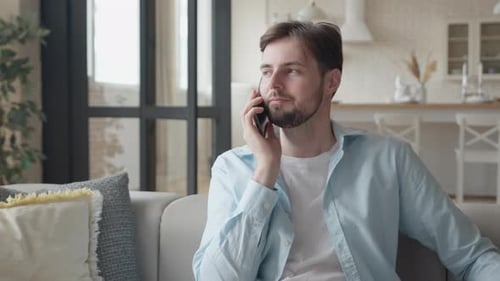 Young Adult Talking on Phone on Home Sofa