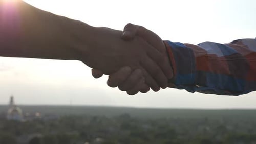Friendly Handshake of Two Unrecognizable Men on Cityscape Background Close Up of Men Greeting with