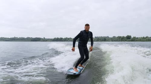 Man Wake Surfing on River Lake Wave
