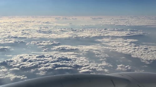 Cloudy sky landscape blue horizon and Airplane flight
Wing of an airplane flying above the clouds wi