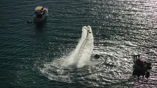 Ein Mann fliegt auf einem Flyboard bei Sonnenuntergang