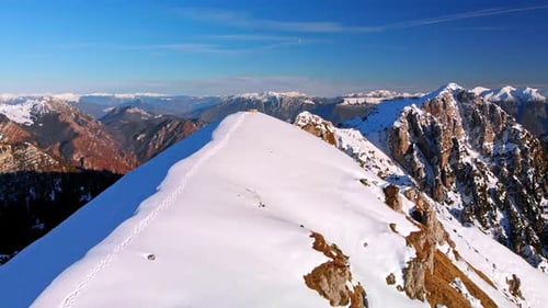 Hoch über den höchsten Bergen fliegen, Schnee bedeckt den Kamm, ein Pfad auf dem Berg. Diese Aufnahme