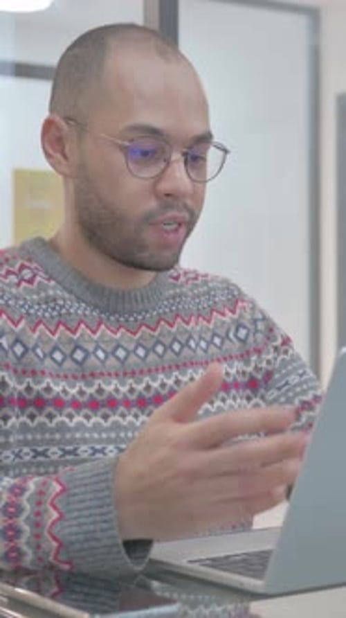 Young Man Video Conferencing on Laptop Indoors