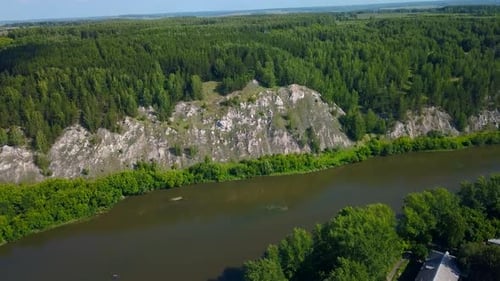 Aerial view of wild nature with rock cliff and endless forest