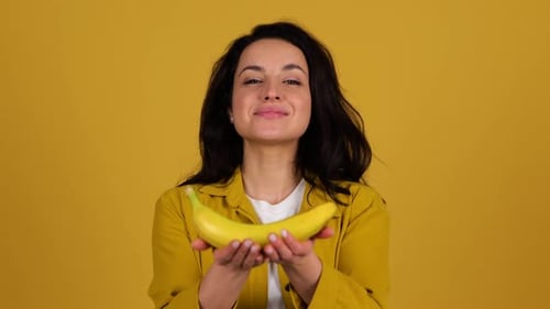 Smiling Woman Holding Out a Banana
