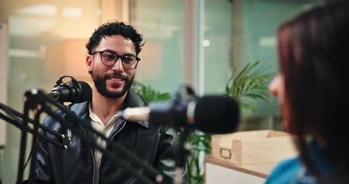 Woman, man and discussion for interview with microphone, podcast and questions for studio guest