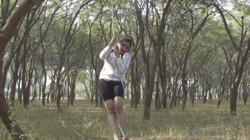 A sporty gymnast performs exercises with a rope in sportswear.Concept: power, strength, healthy life