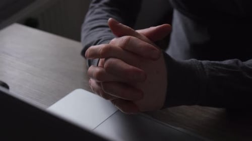 An Unrecognizable Man Crossed His Arms While Sitting at a Table and a Computer Concept of Decision
