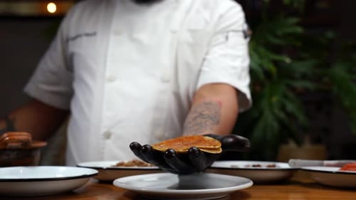 Latin chef taking tortilla and beans for taco recipe in mexican restaurant