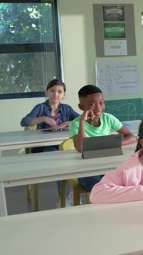 Teacher walking aisle in class, student raising hand asking question, animated icon hovering tablet
