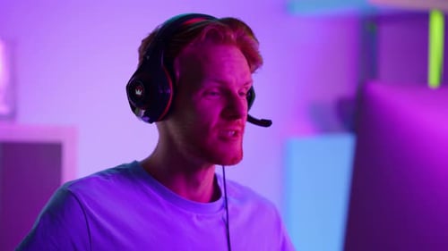 Excited gamer man wearing headset playing video game