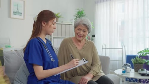 Asian beautiful caregiver examine senior woman patient at nursing home.
